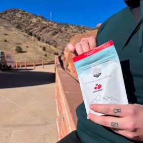 Person enjoying a pack of DELTA-8 THC infused gummies from DENEX